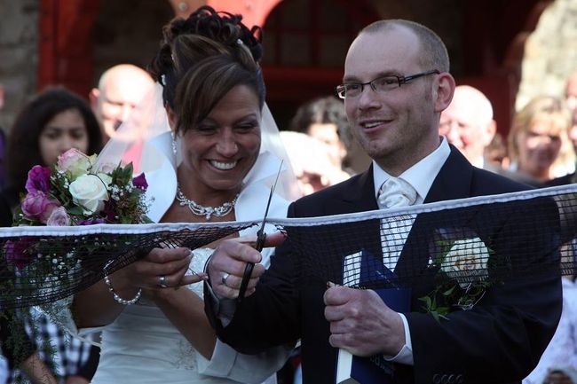 Tünde und Jürgen zerschneiden ein Tischtennisnetz auf ihrer Hochzeit